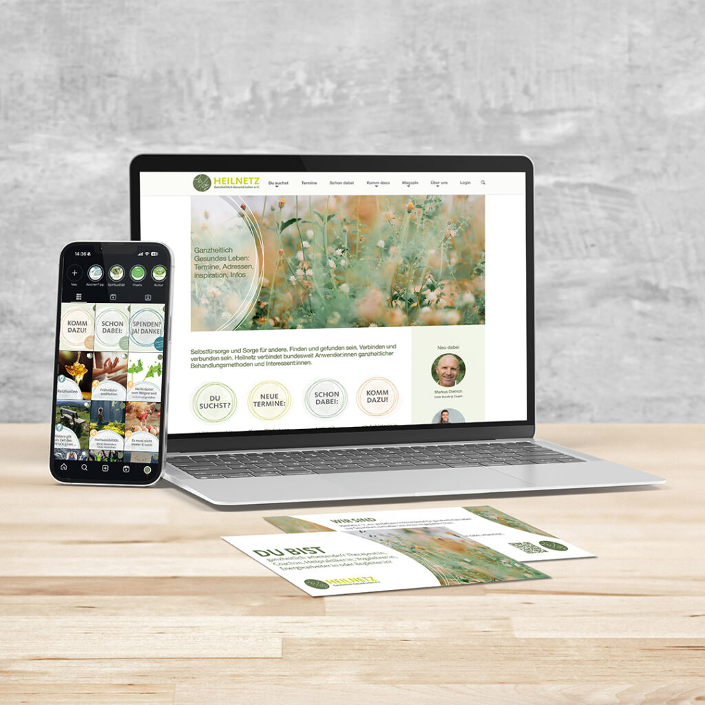 Ein Laptop mit Smartphone und Flyern stehen bzw. liegen auf einem hellen Holztisch. Die Wand im Hintergrund ist aus Beton. Auf dem Laptop-Bildschirm ist die Website Heilnetz.de geöffnet. Auf dem Smartphone-Bildschirm ist die Instagramseite des Heilnetzes zu sehen und die Flyer sind eine Werbung, die Menschen aus Heilberufen zum Mitmachen im Heilnetz einlädt.